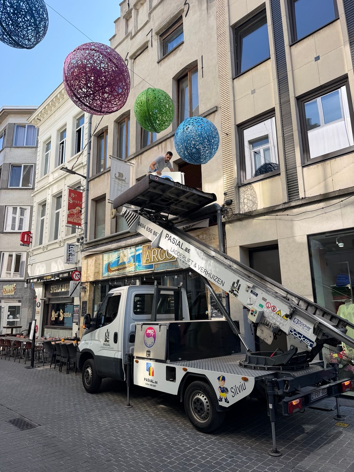 Pasial verhuislift met operator bij een raam in Antwerpen