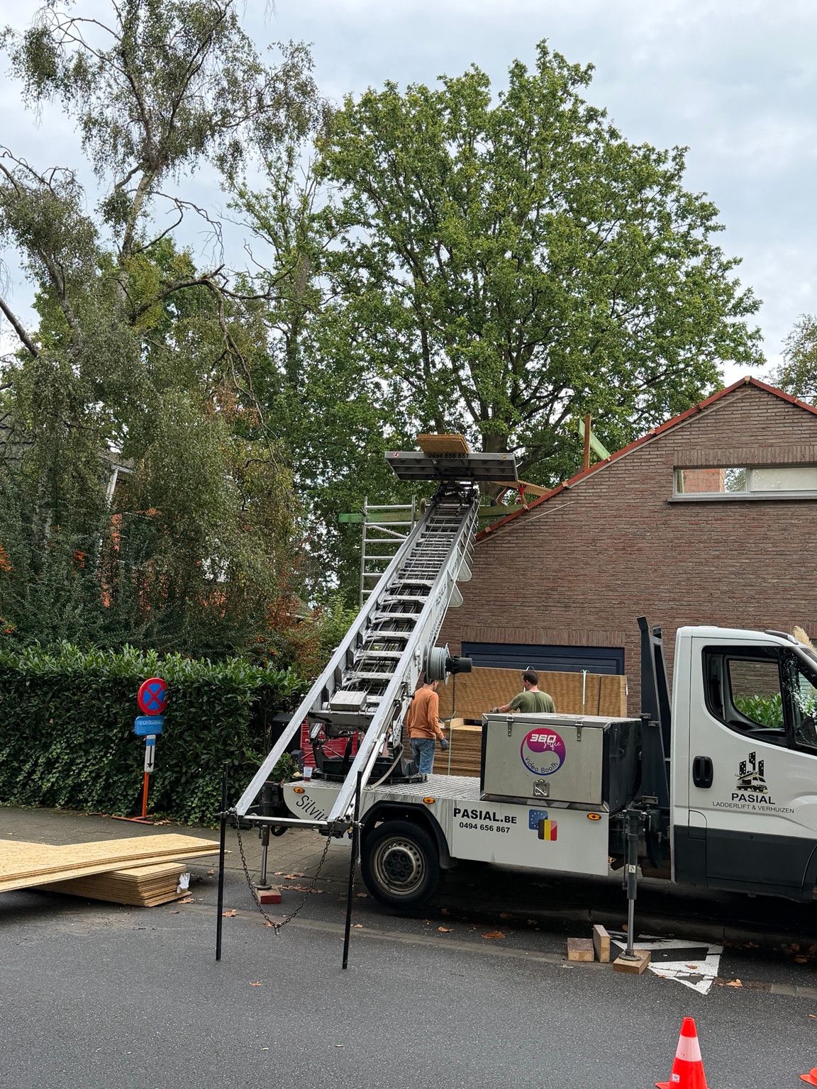 Houten bouwplaten naar dakhoogte brengen met de ladderlift van Pasial in Ekeren.